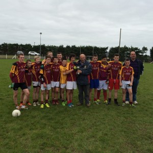 Captain Johnny Heneghan accepts the cup from South Mayo GAA Board chairman Ger McHugh. 